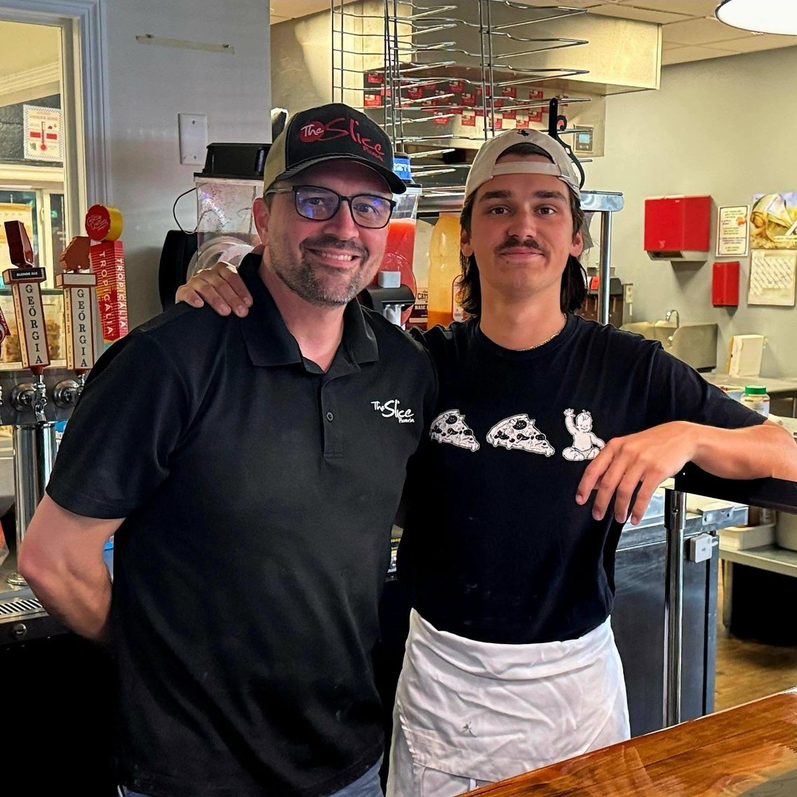 Estel Powell and his son Caden behind the counter at The Slice Pizzeria in Hahira, GA